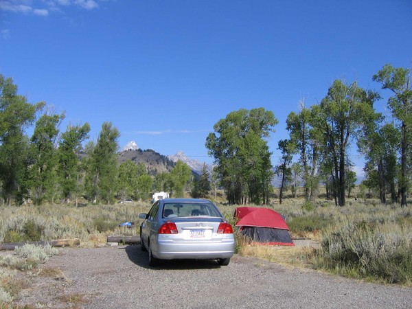 Gros Ventre campsite with red tent and silver sedan surrounded by sagebrush and cottonwoods