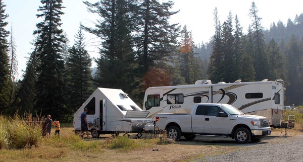Truck with camping trailer, RV at campsite